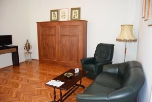 ein Wohnzimmer mit einem Ledersessel und einem Tisch in der Unterkunft Contessa Apartment Cluj Napoca in Cluj-Napoca