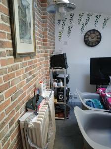 a room with a brick wall and a table with a radiator at suite nature huelgoat in Bannalec