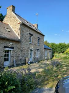 an old stone house with a car parked in front at suite nature huelgoat in Bannalec