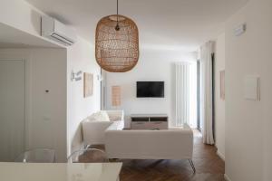 a white living room with a couch and a tv at Residence Atlantico in Lido di Jesolo