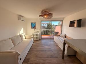 a living room with couches and a table and a view at Le Petit Bleu Studio - Boulouris in Saint-Raphaël