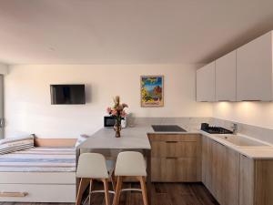 a kitchen with white cabinets and a table and chairs at Le Petit Bleu Studio - Boulouris in Saint-Raphaël