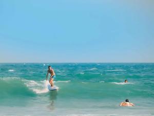 a man riding a wave on a surfboard in the ocean at SH Villa in Weligama