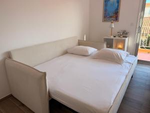 a bed with white sheets and pillows in a room at Le Petit Bleu Studio - Boulouris in Saint-Raphaël