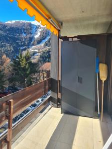a large glass door on a balcony with a view at Studio rénové Ovronnaz chalet Orion in Ovronnaz