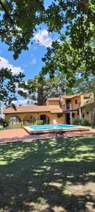a building with a swimming pool in front of a yard at Ex Hostal del Parque in Villa Constitución