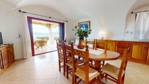 a kitchen with a table and chairs and a dining room at Villetta Ginepri in Cannigione