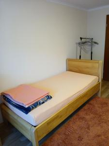 a bed with a wooden frame and a white wall at Ferienwohnung Kulla in Albstadt