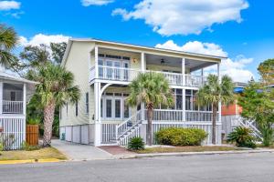 a white house with palm trees in front of it at Front Porch Lounge in Tybee Island