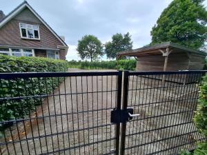 a black fence with a gate in front of a house at Wedderhoeske in Wedde