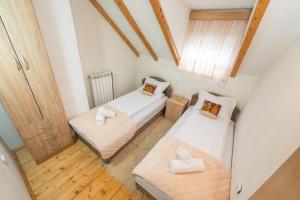 a small room with two beds and a window at Our House Apartments in Kolašin