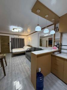 a kitchen and a living room with a couch at JMATS Homestay in Dipolog