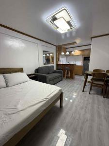a bedroom with a bed and a living room at JMATS Homestay in Dipolog