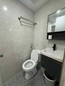 a bathroom with a white toilet and a sink at JMATS Homestay in Dipolog