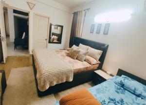 a bedroom with a large bed and a mirror at Budget Condo Family Stay 2 BHK in Mohali