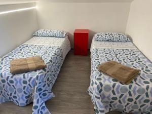 two beds in a small room with at Dimora Coacci in Grottammare