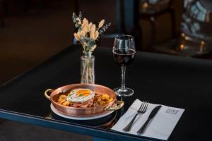 ein Tisch mit einer Schüssel Essen und einem Glas Wein in der Unterkunft HF Fénix Lisboa in Lissabon