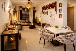 a living room with a couch and a table and chairs at Budget Condo Family Stay 2 BHK in Mohali +23 photos
