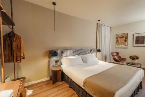 a hotel room with a large bed and a chair at H Regas Adults Only in Barcelona