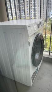 a washing machine sitting in front of a window at Vinsmart City Cam Cam homestay in Phú Thú
