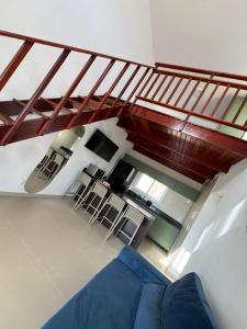 a living room with a blue couch under a staircase at Apto Areia Branca Canoa Quebrada in Canoa Quebrada