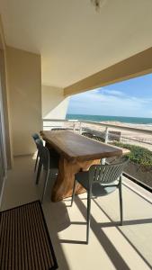 a table and chairs on a balcony with a view of the beach at Apto Areia Branca Canoa Quebrada in Canoa Quebrada