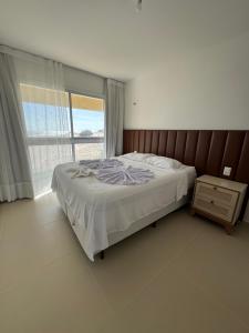 a bedroom with a bed and a large window at Apto Areia Branca Canoa Quebrada in Canoa Quebrada +34 photos