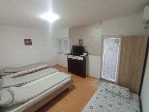 a small room with a bed and a television in it at Apartman TATTOO R in Negotin