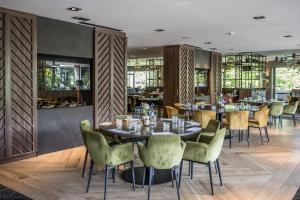 a restaurant with tables and chairs in a room at Van der Valk Hotel Assen in Assen