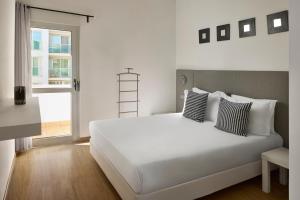 a bedroom with a white bed and a window at Monte Gordo Prestige Apartments in Monte Gordo