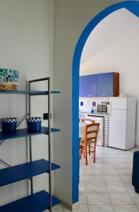 a kitchen and dining room with blue shelves and a table at Casa Kalavrìa a 50mt dal mare in Nicotera Marina