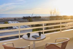 a table and chairs on a balcony with the beach at Monte Gordo Prestige Apartments in Monte Gordo