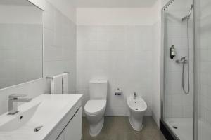 a white bathroom with a toilet and a shower at Monte Gordo Prestige Apartments in Monte Gordo +13 photos