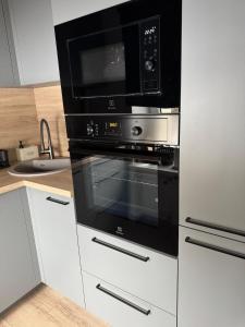 a kitchen with a black oven with a microwave at Central Apartment in Jelgava +44 photos