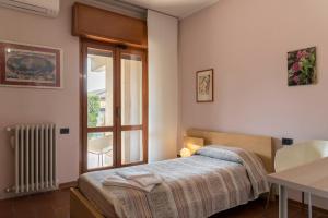 a bedroom with a bed and a table and a window at B&B Orio BGY in Orio al Serio