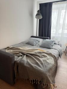 a bedroom with a bed with a blanket on it at Central Apartment in Jelgava