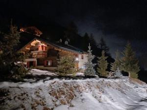 a house in the snow with christmas lights on it at Chalet Renzo Livigno Il lusso del silenzio in Livigno +27 photos