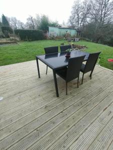 a black table and chairs on a wooden deck at chambre Chez Sylvie in Allaire