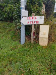 a street sign on a pole in the grass at chambre Chez Sylvie in Allaire