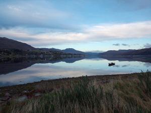 a view of a lake with a boat in it at Rosemarie's B&B in Lochcarron