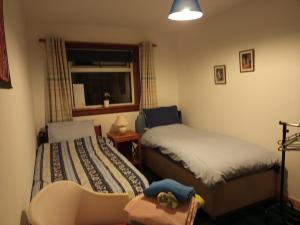 a bedroom with two beds and a window at Rosemarie's B&B in Lochcarron +2 photos