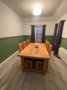 a dining room with a wooden table and chairs at Old Swan Cottage in Great Massingham