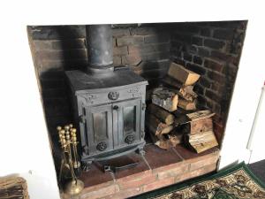 an old wood stove in a brick fireplace at Old Swan Cottage in Great Massingham +15 photos