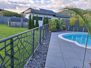 a fence next to a swimming pool in a yard at GITE DE LA PIERRE PLATE in Le Thillot