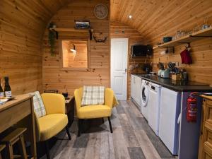 a kitchen with yellow chairs in a log cabin at Gorse Gorgeous Glamping Hideaway in Dundonnell