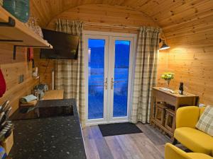 a living room with a large window in a cabin at Gorse Gorgeous Glamping Hideaway in Dundonnell