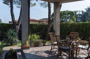 a patio with chairs and a table and a hammock at B&B Orio BGY in Orio al Serio