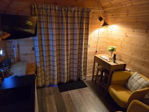 a living room with a couch and a desk in a cabin at Gorse Gorgeous Glamping Hideaway in Dundonnell