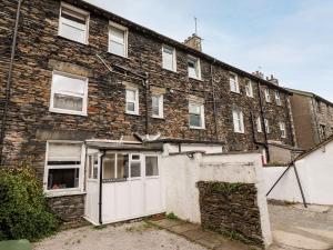an old brick building with a white garage at Waterhead Cottage in Ambleside