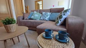 a living room with a couch and two cups on a table at Casa Anibal in Burón